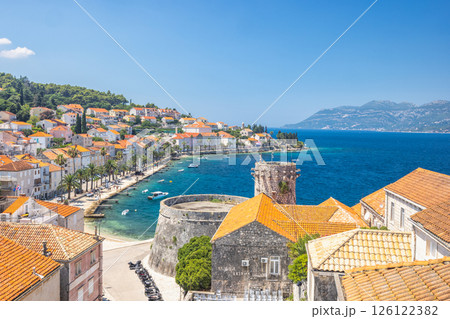 Korcula town in island of Korcula in Adriatic sea in Croatia, Europe. Picturesque coastal town with historic architecture, turquoise waters, and lush greenery under a clear blue sky. Korcula town in island of Korcula in Adriatic sea in Croatia, Europe. Picturesque coastal town with historic architecture, turquoise waters, and lush greenery under a clear blue sky. 126122382