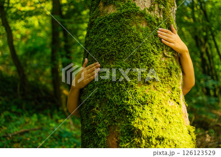 Human Hands Hugging Mossy Tree in Forest Human Hands Hugging Mossy Tree in Forest 126123529