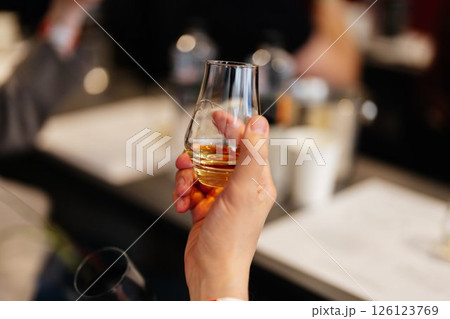 Enjoying a fine glass of whiskey during a relaxing evening gathering 126123769