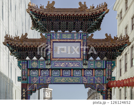 View of London Chinatown entrance gate in traditional chinese design with glazed yellow tiles, a golden dragon, painted panels, two white jade plaques. 126124652