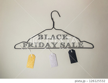 Black Friday sale sign is hanging on a clothes hanger Black Friday sale sign is hanging on a clothes hanger 126125532