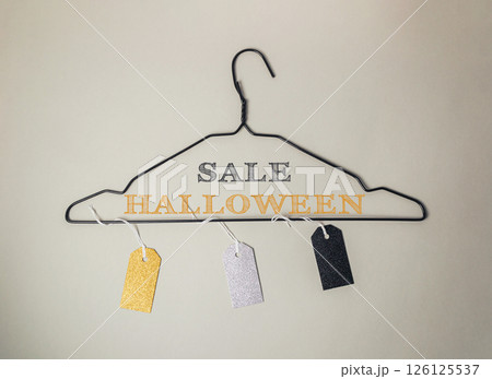 A clothes hanger with tags on it that say Sale Halloween A clothes hanger with tags on it that say Sale Halloween 126125537