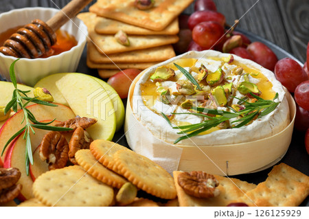 Baked Camembert with honey, pistachios, top view Baked Camembert with honey, pistachios, top view 126125929