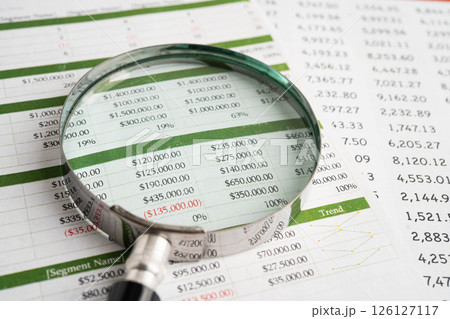Magnifying glass on spreadsheet paper. Magnifying glass on spreadsheet paper. 126127117