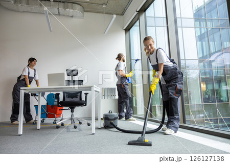 Housekeeping team cleaning the conference room and looking busy and involved 126127138