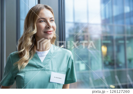 Pretty blonde female doctor in green lab coat near the window in the hospital 126127260