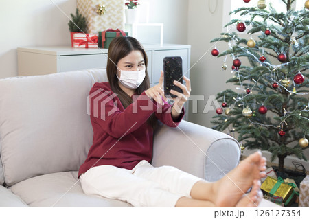 Beautiful Asian woman feel lonely and depressed with smartphone at home during Christmas holiday season. Beautiful Asian woman feel lonely and depressed with smartphone at home during Christmas holiday season. 126127354