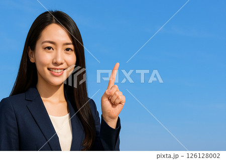 指で1番を示す若い女性（青空背景・コピースペースあり） 126128002