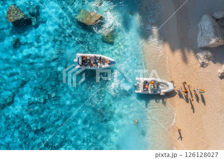 Aerial view of boat, sandy beach, blue sea with waves at sunset Aerial view of boat, sandy beach, blue sea with waves at sunset 126128027
