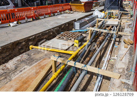 Detailed View of Construction Trench with Pipes and Cables Being Laid for Utility Services Detailed View of Construction Trench with Pipes and Cables Being Laid for Utility Services 126128709