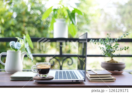 chilling balcony workspace with coffee drink and laptop side view 126129171