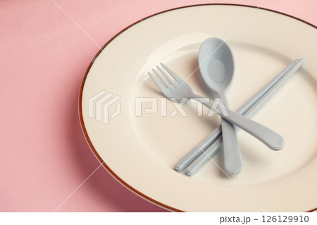Plant Body Parts Pale White Plate with Grey Spoon, Chopsticks and Fork in one plate with Pink background, Negative Space with text Plant Body Parts Pale White Plate with Grey Spoon, Chopsticks and Fork in one plate with Pink background, Negative Space with text 126129910