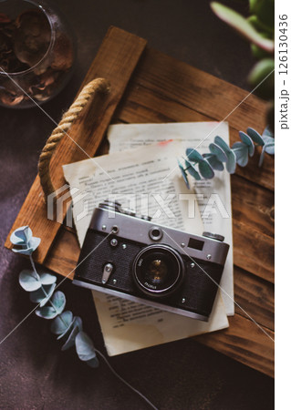 Retro camera on old book and eucalyptus branch on wooden background, flat lay. Vintage style. Retro camera on old book and eucalyptus branch on wooden background, flat lay. Vintage style. 126130436