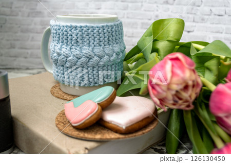 Pink tulips blurred foreground, open book and a mug of freshly brewed coffee or tea. Spring set. 126130450