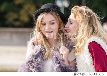 Two fashionable women gossiping Two fashionable women gossiping 126131297
