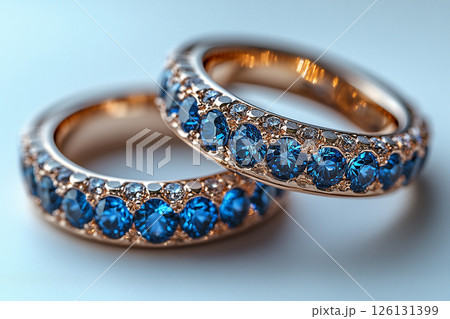 Luxurious pair of wedding rings with blue stones on a white background. Rococo-Renaissance style. Luxurious pair of wedding rings with blue stones on a white background. Rococo-Renaissance style. 126131399