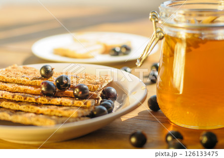 Crunchy Crackers Topped With Ripe Blueberries and Honey in a Sunlit Cozy Kitchen a Food Blog and Cafe Concept 126133475