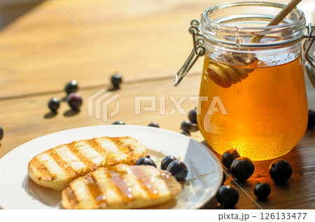 Warm Grilled Pancakes Topped With Syrup and Surrounded by Fresh Blueberries Sit Invitingly on a Plate Warm Grilled Pancakes Topped With Syrup and Surrounded by Fresh Blueberries Sit Invitingly on a Plate 126133477