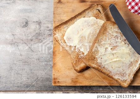 Sliced fresh bread and butter on wooden table Sliced fresh bread and butter on wooden table 126133594