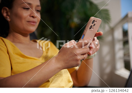 Woman Using Smartphone Outdoors While Relaxing in Bright Daylight Woman Using Smartphone Outdoors While Relaxing in Bright Daylight 126134042