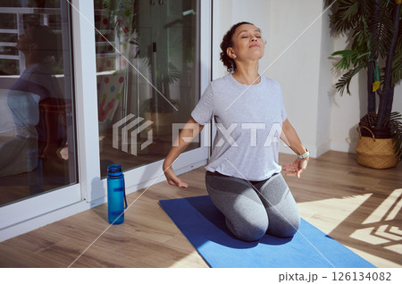 Woman Practicing Relaxing Yoga Breathing Exercises Indoors on a Sunny Morning 126134082