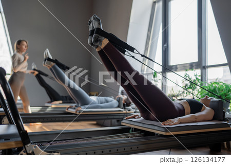 A detailed closeup of a foot work and core exercise on a Balanced Body Reformer machine illuminated by sunlight A detailed closeup of a foot work and core exercise on a Balanced Body Reformer machine illuminated by sunlight 126134177