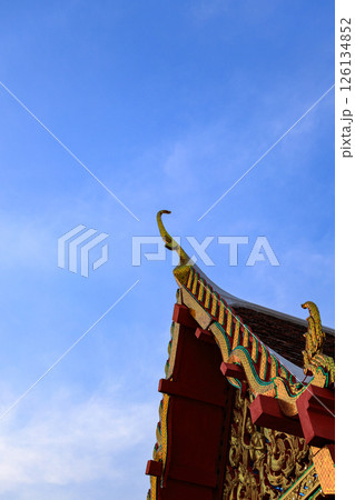 The Vintage traditional Thai Buddhist Temple tiled roof with beautiful blue sky. The Vintage traditional Thai Buddhist Temple tiled roof with beautiful blue sky. 126134852