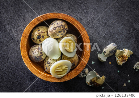 Boiled quail eggs in bowl on black table. Top view. Boiled quail eggs in bowl on black table. Top view. 126135400