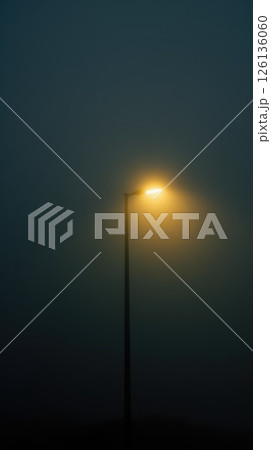 Mysterious streetlight shining in dense fog at nighttime 126136060