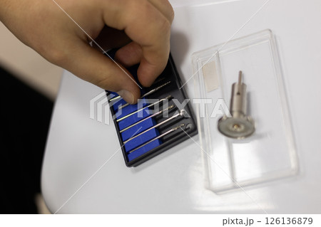 A veterinarian selects a drill from a variety of surgical instruments, prepares for surgery on a pet in a well-equipped veterinary clinic, providing the animal with optimal care. Medical drills. 126136879