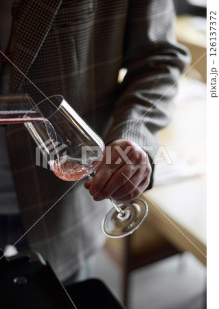 Champagne tasting, The sommelier pours sparkling wine from the decanter into a beautiful glass, Wine glasses are on the table, stylish table setting, sparkling wine bubbles Champagne tasting, The sommelier pours sparkling wine from the decanter into a beautiful glass, Wine glasses are on the table, stylish table setting, sparkling wine bubbles 126137372