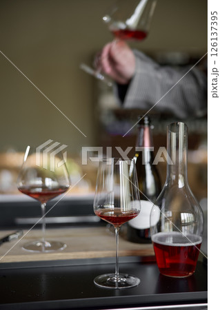 Champagne tasting in restaurant, A man holds in his hand a beautiful elegant glass with rose sparkling wine Champagne tasting in restaurant, A man holds in his hand a beautiful elegant glass with rose sparkling wine 126137395