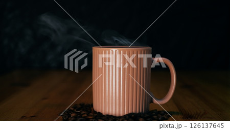 Moody close-up focusing on ceramic mug emitting gentle steam, mug emphasizing handcrafted shape and warm ambiance, mug perfect for premium coffee branding and sophisticated cafe promotions worldwide. Moody close-up focusing on ceramic mug emitting gentle steam, mug emphasizing handcrafted shape and warm ambiance, mug perfect for premium coffee branding and sophisticated cafe promotions worldwide. 126137645