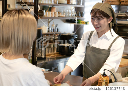 会計処理をするカフェ店員と女性客 会計処理をするカフェ店員と女性客 126137748