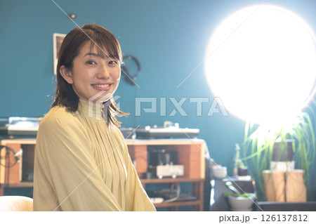丸い窓の喫茶店でくつろぐ若い女性 126137812