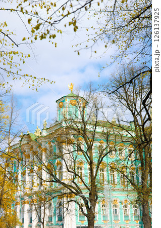 the incredibly picturesque facade of the Winter Palace through the branches of trees on a clear spring day, the heritage of Russia, the most famous landmark of St. Petersburg, the museum the incredibly picturesque facade of the Winter Palace through the branches of trees on a clear spring day, the heritage of Russia, the most famous landmark of St. Petersburg, the museum 126137925