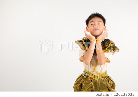 Portrait Thailand kid boy smiling traditional Thai dress costume raises her fists in celebration of her success, studio isolated white background, primary child saying yes with excitement winning 126138033