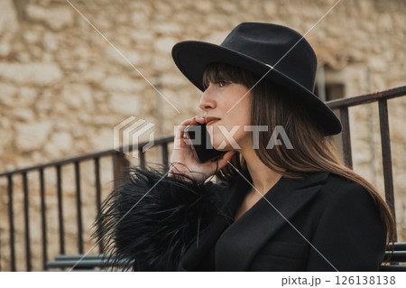Elegant Black Dressed Woman On The Town Bench Having A Fun Call Close Up Elegant Black Dressed Woman On The Town Bench Having A Fun Call Close Up 126138138