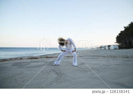 Girl in White Dancing Hip Hop on a Quiet Beach at Sundown Girl in White Dancing Hip Hop on a Quiet Beach at Sundown 126138141