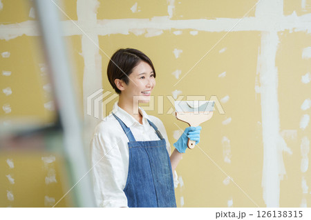 石膏ボードにパテを塗るDIYする女性 石膏ボードにパテを塗るDIYする女性 126138315