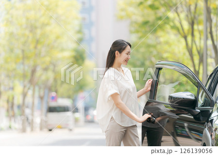 車の前に立つ若い女性 126139056