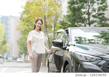 車から降りる若い女性 126139258