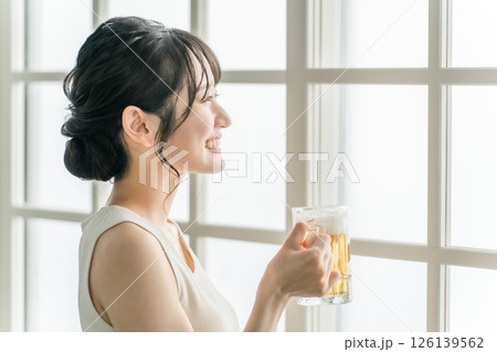 家でビールを昼飲みするアジア人女性（ビールジョッキ） 126139562
