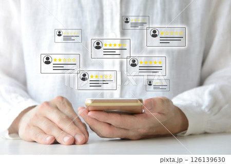 スマホでカスタマーレビューをチェックする人物のイメージ画像 スマホでカスタマーレビューをチェックする人物のイメージ画像 126139630