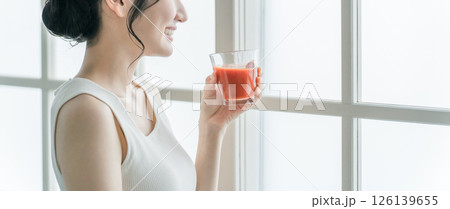 家で朝赤い飲み物を飲むアジア人女性（トマトジュース・レッドスムージー・アセロラジュース） 126139655