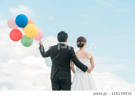 風船を持つ新郎新婦の後ろ姿(ウェディング・結婚式・ブライダル・フォトウェディング) 風船を持つ新郎新婦の後ろ姿(ウェディング・結婚式・ブライダル・フォトウェディング) 126139916