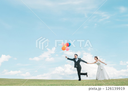青空の中風船を持って走る新郎新婦(ウェディング・結婚式・ブライダル・フォトウェディング) 青空の中風船を持って走る新郎新婦(ウェディング・結婚式・ブライダル・フォトウェディング) 126139919
