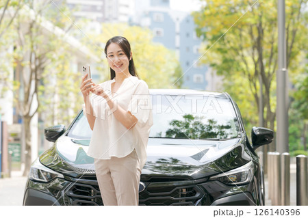 車の前でスマホを見る女性 車の前でスマホを見る女性 126140396