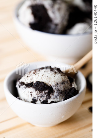 Cookies and cream ice cream in a white bowl. 126140440