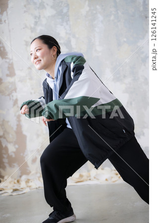 ダンスのポーズ　ダウンを踊るダンサー　ヒップホップなどのお洒落なストリートファッションのイメージ 126141245